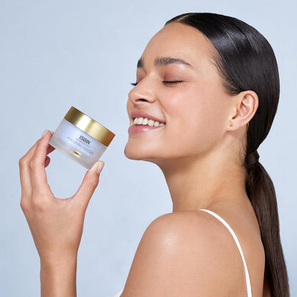 Woman holding a skincare product with a plain background