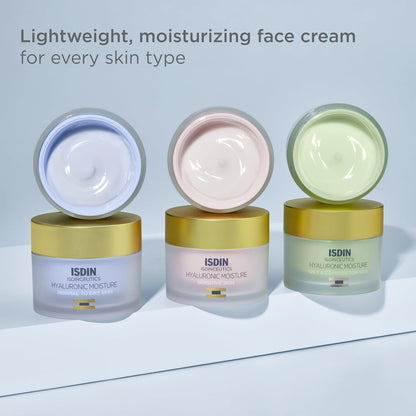 Three open jars of ISDIN moisturizing face cream on a light blue background