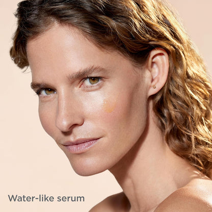 Woman with a water-like serum applied to her face on a beige background