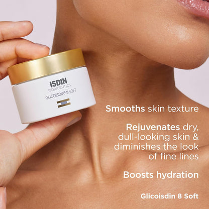 Hand holding a jar of ISDIN skincare product with text highlighting benefits on a blurred background
