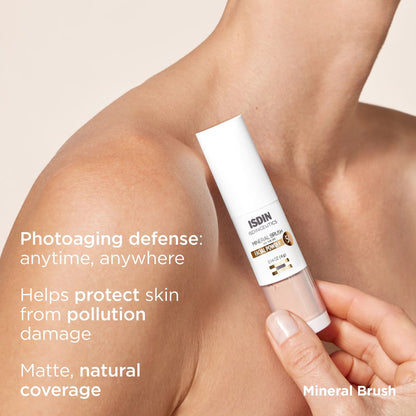 Hand holding a skincare product with text about photoaging defense on a beige background