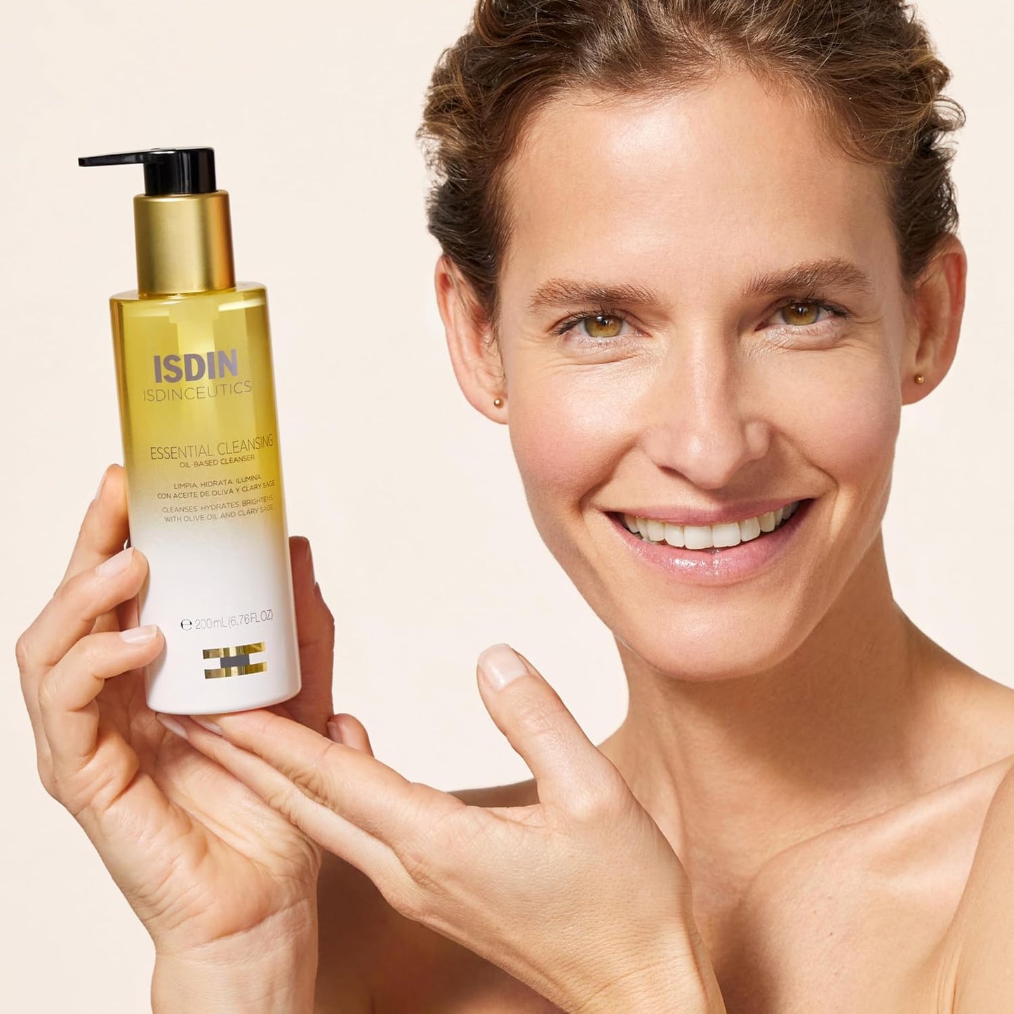 Woman holding a skincare product with ISDIN branding on a beige background