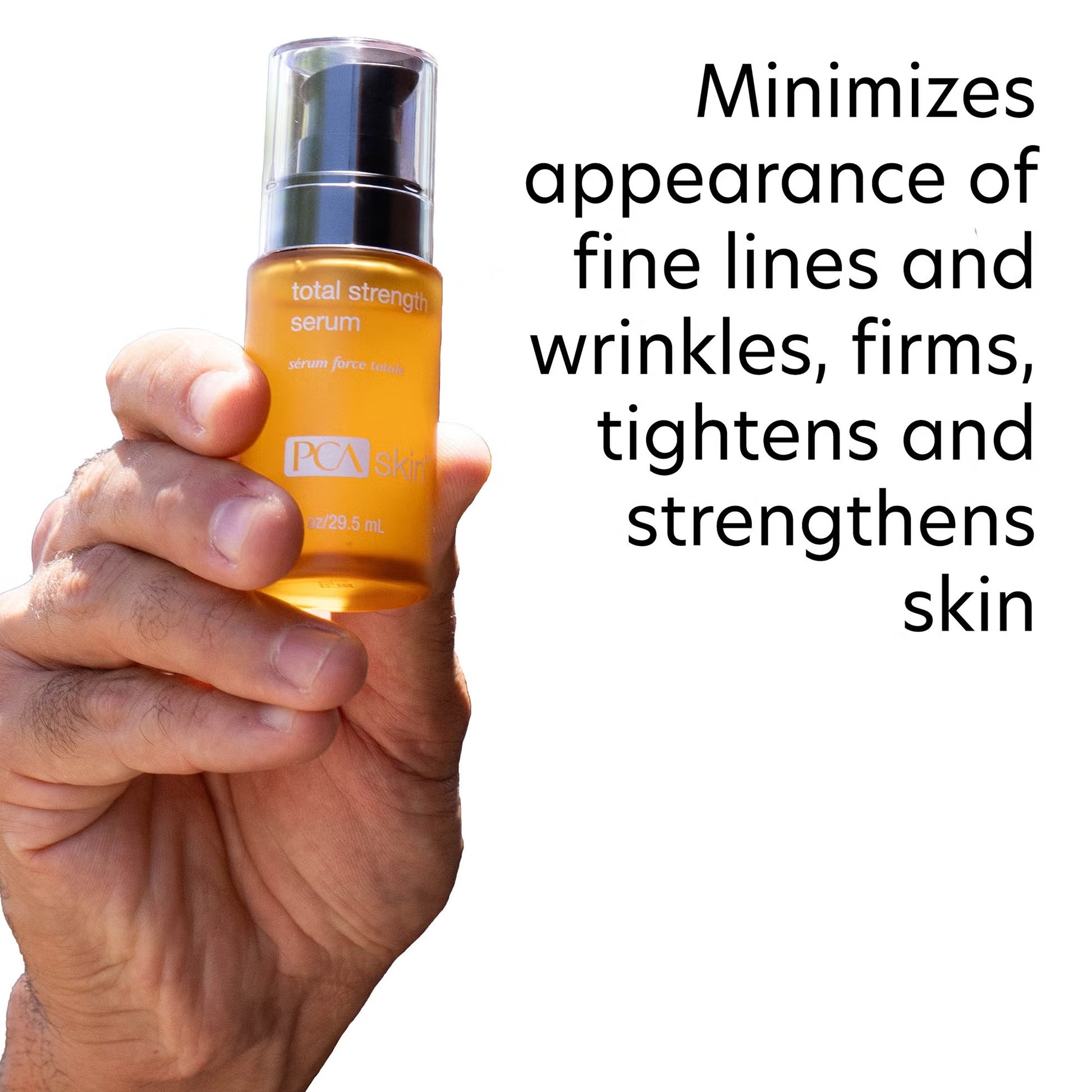 Hand holding a PCA Skin total strength serum bottle with text about skin benefits on a white background